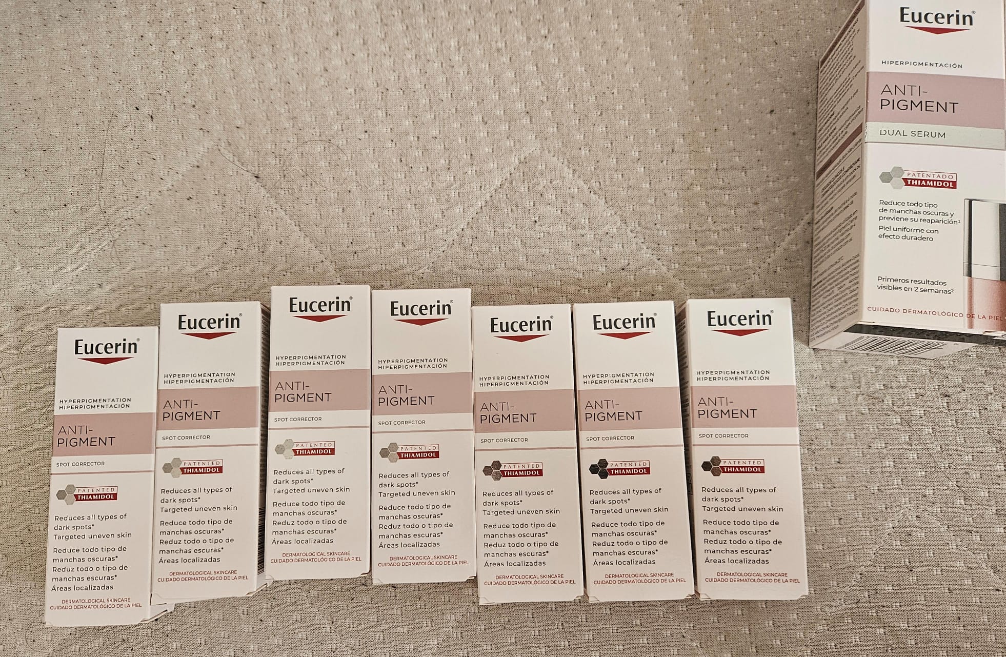 Multiple Eucerin Anti-Pigment Spot Corrector and Dual Serum product boxes arranged on a textured surface.