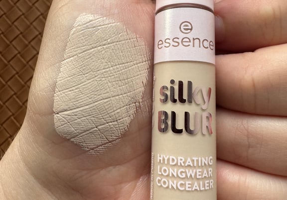 A tube of Essence Silky Blur Hydrating Longwear Concealer with a swatch of light beige product on skin. review