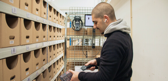 A member of the Logistics Team scans a product during product picking