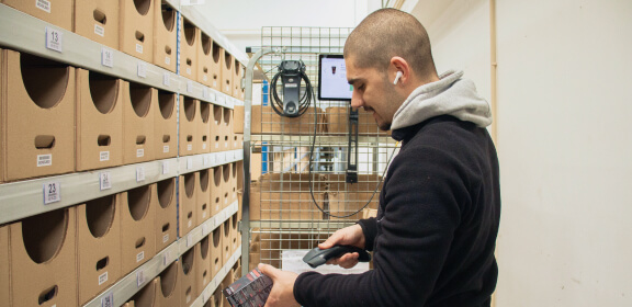 Um membro da equipa de logística verifica um produto durante a separação do produto